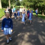 pupils walking in a park in the sunshine