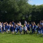large group of pupils preparing to start a long walk in the sunshine