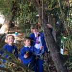 pupils outside hanging recycled items to a tree