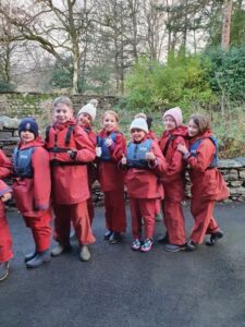 line of pupils wearing red waterproofs on an school trip